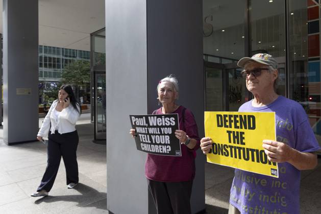 October 7, 2025, New York, New York, USA: Demonstrators with the activist group Rise and Resist hold signs that read Paul, Weiss WHAT WILL YOU TELL YOUR CHILDREN? DEFEND THE CONSTITUTION outside of the offices of Paul, Weiss, Rifkind, Wharton and Garrison LLP in midtown Manhattan. Protesters stage a peaceful demonstration to denounce the law firm s agreement to provide millions in pro bono legal work to initiatives from President Trumpâ€⠢s agenda and to abandon diversity, equity, and inclusion (DEI) policies. New York USA - ZUMAr174 20251007_znp_r174_037 Copyright: xGinaxMxRandazzox