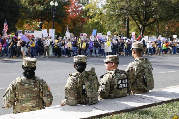 October 18, 2025, Washington Dc, Washington Dc, USA: National Guard members are seen while demonstrators take part in a protest against the Donald Trump administration during the No Kings national rally on October 18, 2025, in Washington, DC, USA. Millions of people across the nation joined the No Kings protest to demonstrate their disapproval of the current US administration. The No Kings Day of Defiance has been organized to reject authoritarianism, billionaire-first politics, and the militarization of the countryÃ¢â‚¬â ¢s democracy, according to a statement by organizers. Washington Dc USA - ZUMAk203 20251018_znp_k203_016 Copyright: xAashishxKiphayetx