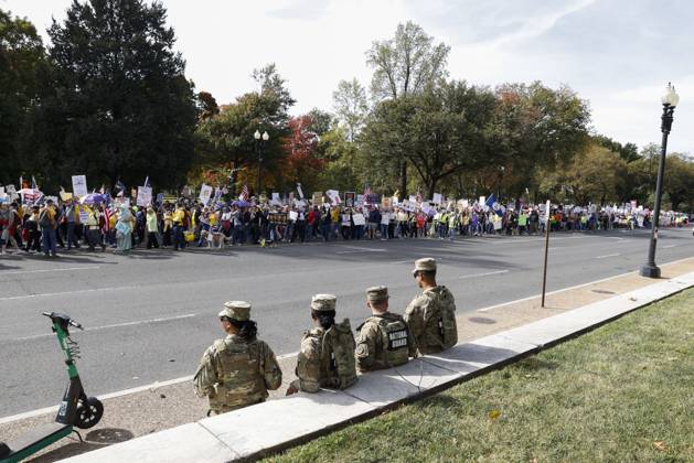 October 18, 2025, Washington Dc, Washington Dc, USA: National Guard members are seen while demonstrators take part in a protest against the Donald Trump administration during the No Kings national rally on October 18, 2025, in Washington, DC, USA. Millions of people across the nation joined the No Kings protest to demonstrate their disapproval of the current US administration. The No Kings Day of Defiance has been organized to reject authoritarianism, billionaire-first politics, and the militarization of the countryÃ¢â‚¬â ¢s democracy, according to a statement by organizers. Washington Dc USA - ZUMAk203 20251018_znp_k203_015 Copyright: xAashishxKiphayetx