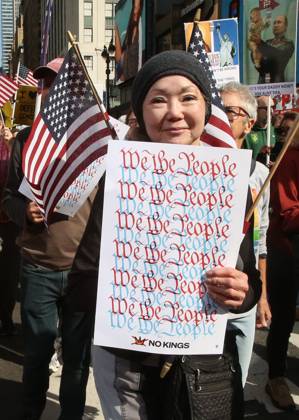 October 18, 2025, New York City, New York, USA: A woman holds a sign that says We the People during the No Kings protest in New York City on Oct. 18, 2025. Tens of thousands of people hit New York City streets to protest Donald Trump, autocracy, ICE and immigrant deportations. More than 2,500 similar protests took place nationwide. New York City USA - ZUMAk45_ 20251018_zaf_k45_044 Copyright: xKristaxKennellx