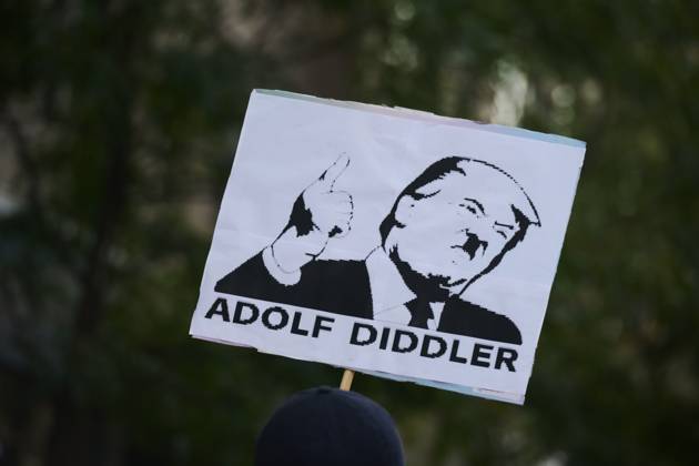 October 18, 2025, New York, New York, USA: Protester holds a sign with an image of Donald Trump with a Hitler style mustache that reads, Ã¢â‚¬oeAdolf DiddlerÃ¢â‚¬Â in the New York City No Kings protest in opposition to measures Donald Trump has taken to install authoritarian style rule. New York USA - ZUMAl171 20251018_znp_l171_031 Copyright: xEdnaxLeshowitzx