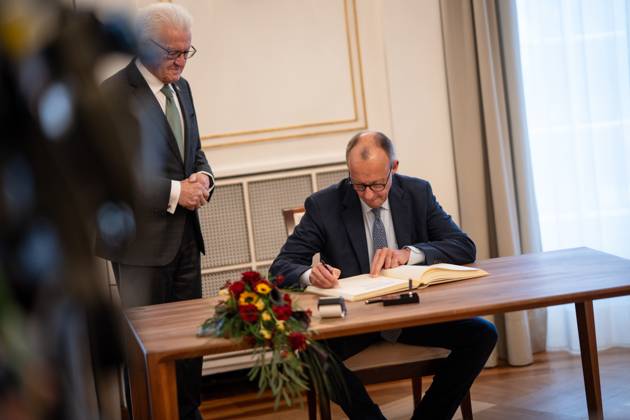 Federal Chancellor Friedrich Merz signs the guest book of the state of Baden Württemberg in the presence of Minister President Winfried Kretschmann Inaugural visit of the Federal Chancellor to Baden Württemberg, Villa Reitzenstein in Stuttgart, Stuttgart Baden Württemberg Germany Villa Reitzenstein