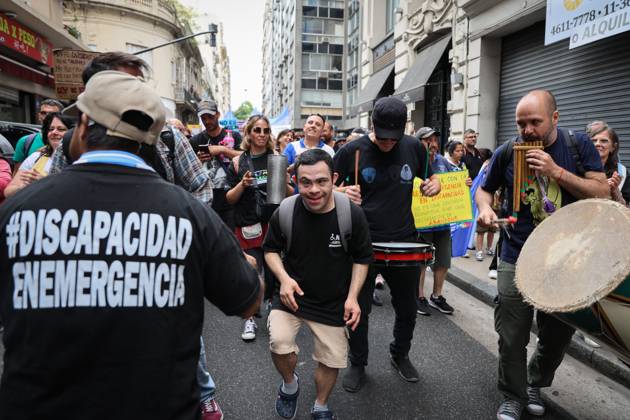 October 22, 2025, Buenos Aires, Buenos Aires, Argentina: A young man with Down syndrome dances accompanied by musicians during the demonstration calling for enforcement of the Disability Emergency Law. Buenos Aires Argentina - ZUMAp265 20251022_zip_p265_002 Copyright: xDelfinaxCorberaxPix