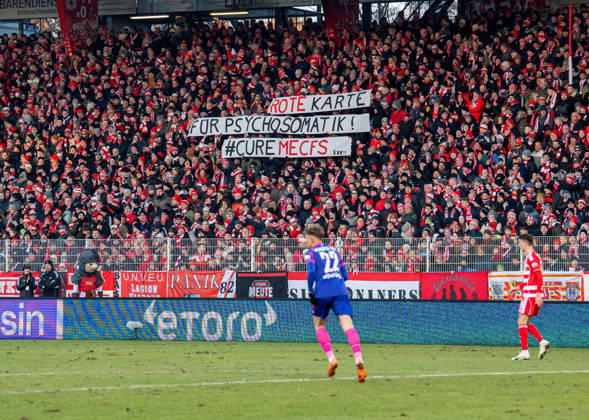 Soccer, Men, Season 2025 2026, 1 Bundesliga 16 Matchday , 1 FC Union Berlin 1 FSV Mainz 05, Fans of Union with banners Red Card for Psychosomatics CureMECFS, 10 01 2026, Copyright: xSebastianxRäppold MatthiasxKochx