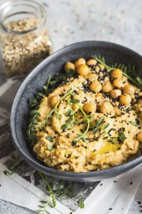 Kichererbsenhummus in der schwarzen Schale, dekoriert mit Sesamsamen und Kichererbsengrün. Vegane Rezepte, Gerichte auf pflanzlicher Basis. Konzept für umweltfreundliches Wohnen. Biologische Lebensmittel. Vegetarische Küche Chickpeas hummus in the black bowl decorated with sesame seeds and chickpeas greens. Vegan recipes, plant-based dishes. Green living concept. Organic food. Vegetarian cuisine Copyright: imageBROKER NataliiaxZhekova ibxiqx16147411