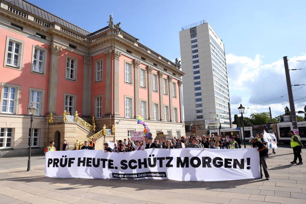 Protesters carrying a banner reading Review today, ban tomorrow march around the state parliament during a demonstration calling for the Federal Constitutional Court to review far-right parties, Alter Markt, Potsdam, September 12, 2026. Review Demonstration in Potsdam