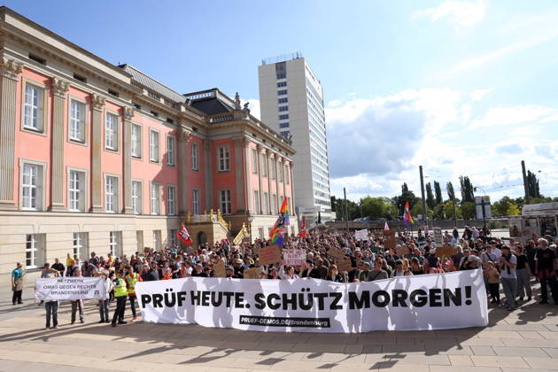 Protesters carrying a banner reading Review today, Schütz tomorrow march around the state parliament during a demonstration calling for the Federal Constitutional Court to review far-right parties, Alter Markt, Potsdam, September 12, 2026. Review demonstration in Potsdam