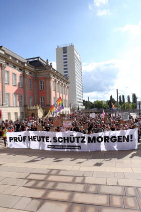 Protesters carrying a banner reading Review today, Schütz tomorrow march around the state parliament during a demonstration calling for the Federal Constitutional Court to review far-right parties, Alter Markt, Potsdam, September 12, 2026. Review demonstration in Potsdam