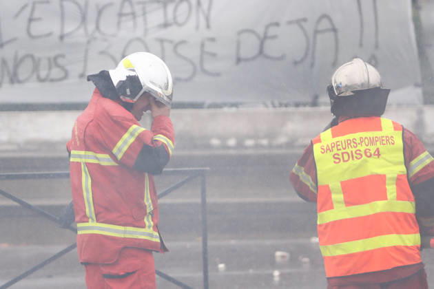October 1, 2026, Anglet, Nouvelle Aquitaine, France: A firefighter rubs his eyes, irritated by smoke, as a colleague holds a hose during a protest outside the Lyco e Cantau in Anglet, southwestern France, on October 1, 2026, against overcrowded classes and a lack of resources. The movement, which began in the Paris region a week ago, has spread across France, with hundreds of high schools blocked. Anglet France - ZUMAb298 20261001_zsp_b298_028 Copyright: xJulesxBuonx