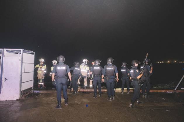 October 3, 2026, Ceuta, Ceuta, Spain: Riot police officers and firefighters line up next to the portable toilets of a makeshift migrant camp in Ceuta at night. Riot police escorted firefighters through the camp on the night of October 3 to put out the fires that people living there use to cook their food. Thousands of migrants, most of them young Moroccan men, have been living in makeshift settlements in the Spanish North African enclave of Ceuta since a mass arrival at the end of July 2026 set off a migration and political crisis. Ceuta Spain - ZUMAs392 20261003_zip_s392_020 Copyright: xFabianxSuspensivox