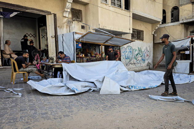 Palestinian Tailor Repairs Tent Covers for Displaced Families in Khan Younis Palestinian tailor Shaaban al-Tabash repairs and assembles tarpaulins and plastic sheets using rudimentary methods to reinforce the tents of displaced Palestinians and protect them from cold weather and rain in Khan Younis, in the southern Gaza Strip, on October 4, 2026. As winter approaches, shortages of protective supplies and the deterioration of many tents after nearly three years of war are worsening living conditions, while al-Tabash uses available materials to extend the life of shelters that have become the last refuge for thousands of displaced people. Photo by Tariq Mohammad APA Images Khan Yunis Gaza Strip Palestinian Territory 041026_Khan_Yunis_TM_01( Copyright: xapaimagesxTariqxMohammad xapaimagesx