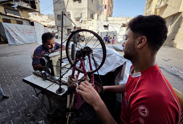 Palestinian Tailor Repairs Tent Covers for Displaced Families in Khan Younis Palestinian tailor Shaaban al-Tabash repairs and assembles tarpaulins and plastic sheets using rudimentary methods to reinforce the tents of displaced Palestinians and protect them from cold weather and rain in Khan Younis, in the southern Gaza Strip, on October 4, 2026. As winter approaches, shortages of protective supplies and the deterioration of many tents after nearly three years of war are worsening living conditions, while al-Tabash uses available materials to extend the life of shelters that have become the last refuge for thousands of displaced people. Photo by Tariq Mohammad APA Images Khan Yunis Gaza Strip Palestinian Territory 041026_Khan_Yunis_TM_01( Copyright: xapaimagesxTariqxMohammad xapaimagesx