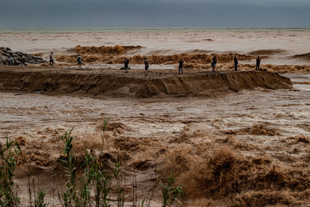 October 4, 2026, Sant Adria Del Besos, Barcelona, Spain: People stays at the mouth of the Besos River, north of Barcelona, swollen and laden with sediment after a night of torrential rain across Catalonia. The storm brought exceptional rainfall to the Barcelona metropolitan area, with more than 200 litres per square metre recorded in parts of the region. The Besos rose sharply overnight, prompting authorities to warn of an imminent risk of flooding. Sant Adria Del Besos Spain  - ZUMAb137 20261004_fap_b137_002 Copyright: xJordixBoixareux