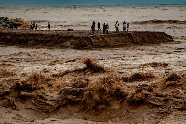 October 4, 2026, Sant Adria Del Besos, Barcelona, Spain: People stays at the mouth of the Besos River, north of Barcelona, swollen and laden with sediment after a night of torrential rain across Catalonia. The storm brought exceptional rainfall to the Barcelona metropolitan area, with more than 200 litres per square metre recorded in parts of the region. The Besos rose sharply overnight, prompting authorities to warn of an imminent risk of flooding. Sant Adria Del Besos Spain - ZUMAb137 20261004_fap_b137_006 Copyright: xJordixBoixareux