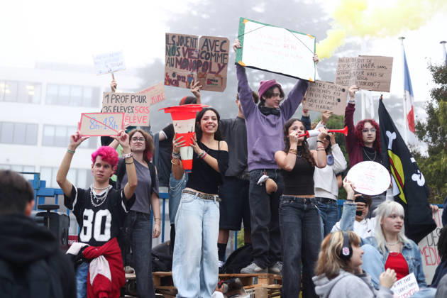 October 5, 2026, Bayonne, Nouvelle Aquitaine, France: High school students hold placards, one reading One teacher for 35 students, 5 riot police for 1 student , and a yellow smoke flare during a protest against the government outside the Reno Cassin high school in Bayonne, southwestern France, on October 5, 2026. Students have been blocking schools across France since September 21 to demand more teachers, smaller classes and better school buildings. Bayonne France - ZUMAb298 20261005_zsp_b298_001 Copyright: xJulesxBuonx