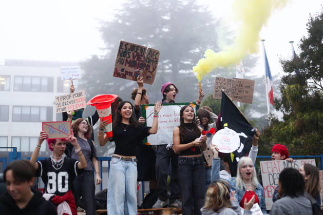 October 5, 2026, Bayonne, Nouvelle Aquitaine, France: High school students hold placards, one reading One teacher for 35 students, 5 riot police for 1 student , and a yellow smoke flare during a protest against the government outside the Reno Cassin high school in Bayonne, southwestern France, on October 5, 2026. Students have been blocking schools across France since September 21 to demand more teachers, smaller classes and better school buildings. Bayonne France - ZUMAb298 20261005_zsp_b298_003 Copyright: xJulesxBuonx