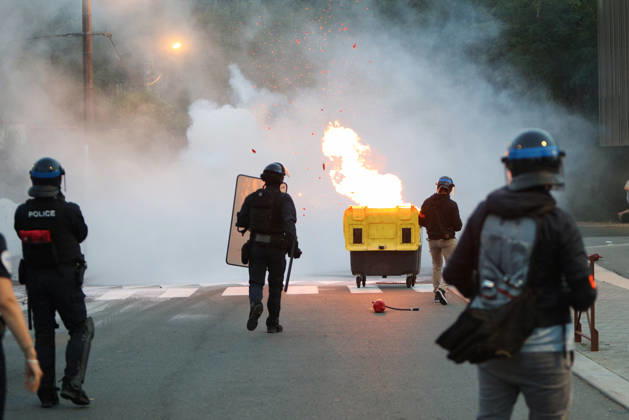 October 5, 2026, Anglet, Nouvelle Aquitaine, France: French police officers advance towards a burning waste container as sparks fly during a protest by high school students against the government outside the Cantau high school in Anglet, southwestern France, on October 5, 2026. Students have been blocking schools across France since September 21 to demand more teachers, smaller classes and better school buildings. Cantau was closed by authorities after clashes in recent days. Anglet France - ZUMAb298 20261005_zsp_b298_005 Copyright: xJulesxBuonx