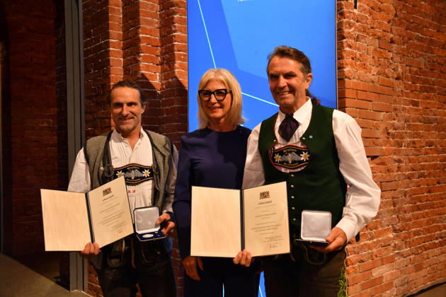 Ulrike Scharf, Bavarian Minister of State, and Alexander and Thomas Huber of Huber Baum; Awarding of the Bavarian State Medal for Social Service 2026; All Saints Day; Hofkirche, Munich; October 6, 2026