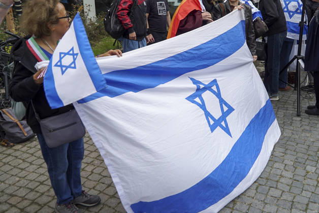 CNTV VIGIL: Demonstrators on the street; participants holding German and Israeli flags at the vigil marking the third anniversary of the attack and massacre in Israel; people gathering in front of the Audimax in the Grindelviertel neighborhood of Hamburg on October 7, 2026, Hamburg, Germany