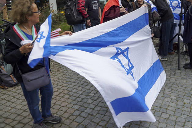 CNTV VIGIL: Demonstrators on the street; participants holding German and Israeli flags at the vigil marking the third anniversary of the attack and massacre in Israel; people gathering in front of the Audimax in the Grindelviertel neighborhood of Hamburg on October 7, 2026, Hamburg, Germany