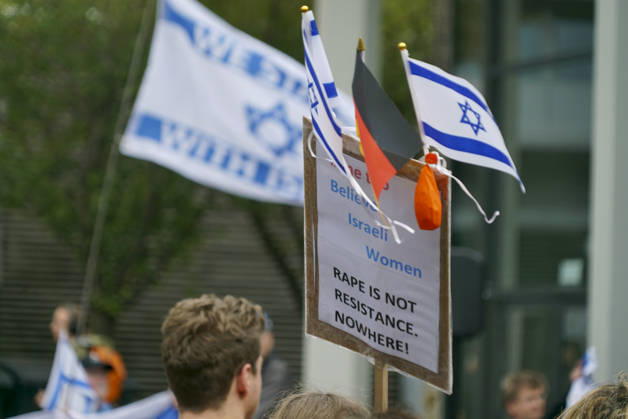 CNTV VIGIL: Demonstrators on the street; participants holding German and Israeli flags at the vigil marking the third anniversary of the attack and massacre in Israel; people gathering in front of the Audimax in the Grindelviertel neighborhood of Hamburg on October 7, 2026, Hamburg, Germany