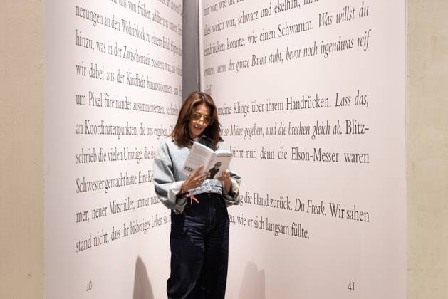 78th Frankfurt Book Fair: A visitor to the Frankfurt Book Fair reads a book inside a giant model of a book. The 78th Frankfurt Book Fair will take place October 7–11, 2026, at the Frankfurt am Main Exhibition Center in Hesse, Germany. 2026-10-07_frankfurter-buchmesse_15