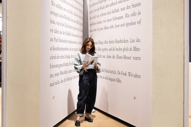 78th Frankfurt Book Fair: A visitor to the Frankfurt Book Fair reads a book inside a giant model of a book. The 78th Frankfurt Book Fair will take place October 7–11, 2026, at the Frankfurt am Main Exhibition Center in Hesse, Germany. 2026-10-07_frankfurter-buchmesse_17