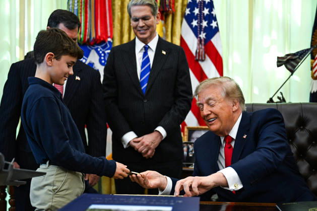 Trump Makes Oval Office Announcement WASHINGTON, DC - OCT. 7: US President Donald Trump hands a challenge coin and a pen to a child during an announcement on Trump Accounts in the Oval Office on Wednesday, Oct. 7, 2026 at the White House in Washington, D.C. (Photo by Annabelle Gordon Pool For The Washington Post) Washington DC United States Copyright: xPool ABACAx