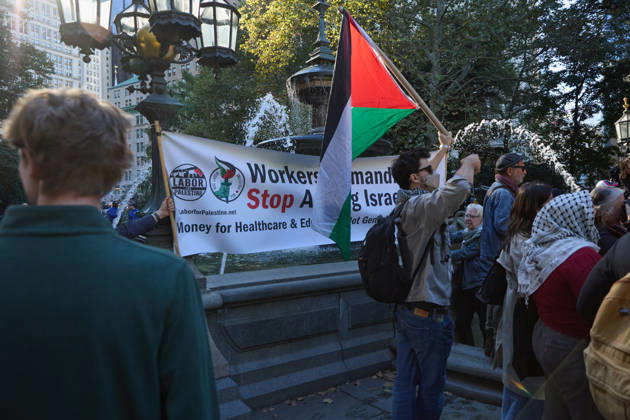 October 7, 2026, New York, New York, USA: A protester holds Palestinian flags beside a banner during a pro-Palestinian demonstration at City Hall Park in New York City, New York. New York USA - ZUMAs237 20261007_aap_s237_017 Copyright: xMarkxJ.xSullivanx
