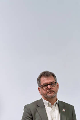 Berlin, October 8, 2026—Werner Graf of Alliance 90 The Greens listens to a joint press statement by The Left Berlin, Alliance 90 The Greens Berlin, and the SPD Berlin in the foyer of the Haus der Statistik after the preliminary talks concluded, with his head tilted to one side. Press Statement by The Left, The Greens, and the SPD in Berlin