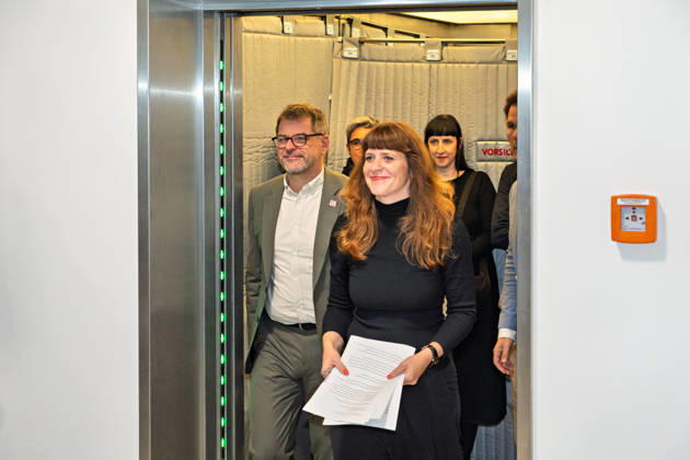 Berlin, October 8, 2026—Kerstin Wolter Ehling of Die Linke (front) and Werner Graf of Alliance 90 The Greens (left) emerge from the elevator following preliminary talks with Die Linke Berlin, Alliance 90 The Greens Berlin, and the SPD Berlin, step out of the elevator to deliver a joint press statement in the foyer of the Haus der Statistik. Press statement by The Left, The Greens, and the SP
