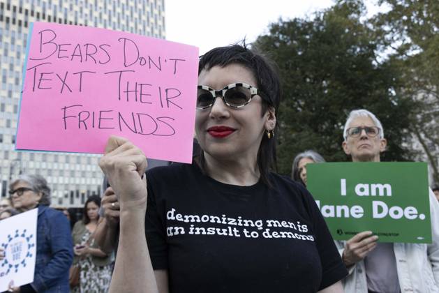 October 8, 2026, New York, New York, USA: A demonstrator wears a shirt that reads demonizing men is an insult to demons and holds a sign that reads Bears Don t TEXT Their FRIENDS joining hundreds at a rally in Foley Square outside the New York State Supreme Court building in Lower Manhattan under the banner . StopSexualViolence: From the Frat House to the White House. The protest is one of many rallies and campus walkouts around the country demanding justice for Cornell s Jane Doe. New York USA - ZUMAr174 20261008_znp_r174_021 Copyright: xGinaxMxRandazzox