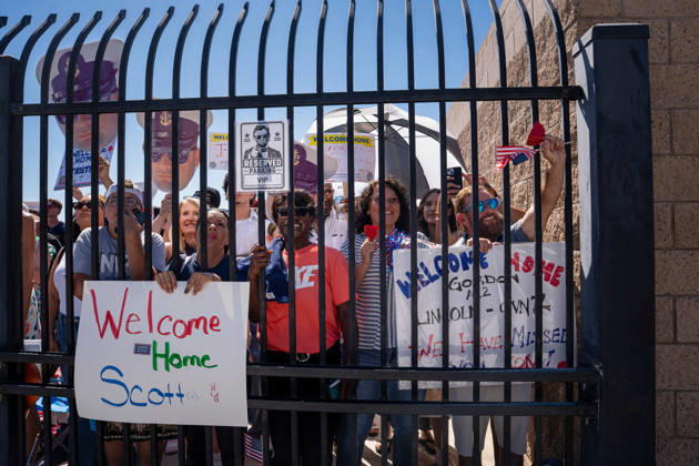 October 8, 2026, Coronado, California, United States: Family members and supporters hold welcome-home signs and wave American flags as they await the return of the aircraft carrier USS Abraham Lincoln (CVN 72) at Naval Air Station North Island in Coronado, California, on October 8, 2026, following a deployment. A sign in the foreground reads Welcome Home Scott. Coronado United States - ZUMAg374 20261008_znp_g374_011 Copyright: xLoganxGrahamx