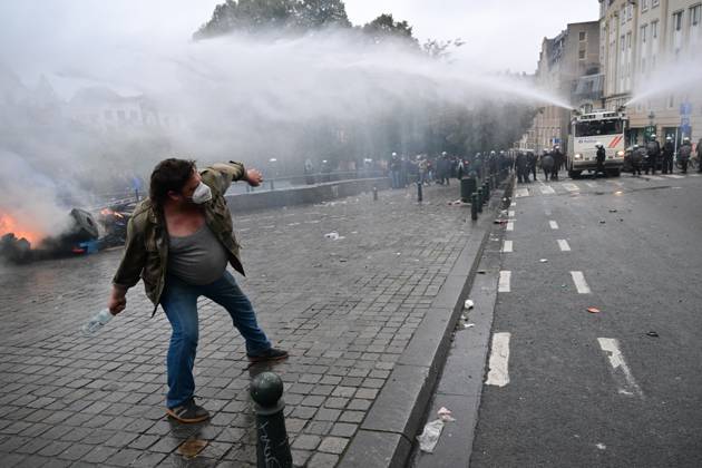 A protestor launches a bottle to the police during a national manifestation against the Federal Government s budgetary measures, under the Keep your hands out of our pockets! (Blijf uit onze zakken! - Pas dans nos poches) moniker, organised by the trade unions on Friday 9 October 2026 in Brussels. DIRKxWAEM 189238723