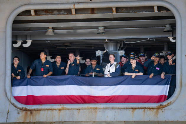 October 8, 2026, Coronado, California, United States: U.S. Navy sailors stand behind red, white and blue bunting aboard the aircraft carrier USS Abraham Lincoln (CVN 72) as the ship returns to Naval Air Station North Island in Coronado, California, on October 8, 2026, following a deployment. One sailor points toward the shore as others look on. Coronado United States - ZUMAg374 20261008_znp_g374_010 Copyright: xLoganxGrahamx