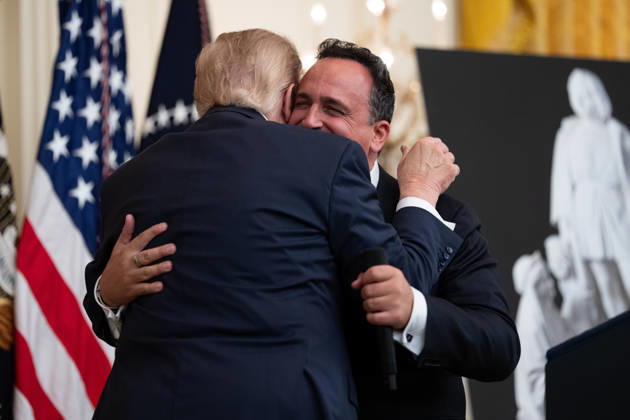 President Donald Trump embraces singer Christopher Macchio during an event in the East Room of the White House in Washington, DC on Friday, Oct. 9, 2026. Trump is hosting a Columbus Day celebration.  WASP20261009107 AaronxSchwartz
