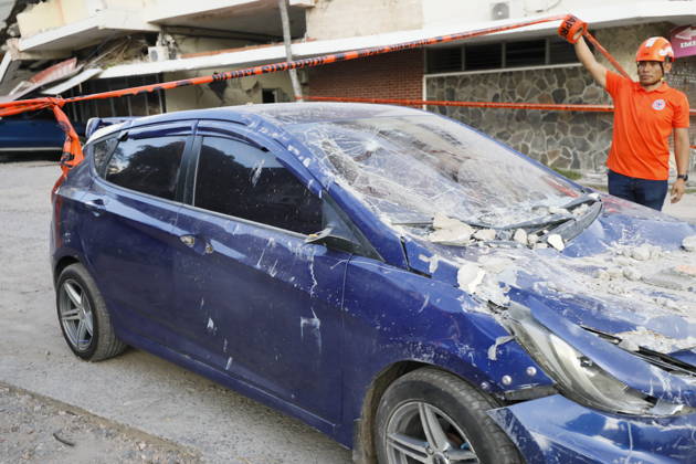 (261009) -- PENONOME(PANAMA), Oct. 9, 2026 -- A rescuer stands beside a damaged vehicle after an earthquake in Penonome, central Cocle Province of Panama, Oct. 9, 2026. A major earthquake struck Panama on Friday. (Photo by Xinhua) PANAMA-PENONOME-EARTHQUAKE DanielxGonzalez 
