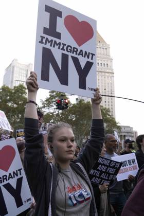 October 9, 2026, New York, New York, USA: A demonstrator wears a shirt that reads Abolish ICE and holds a sign that reads I love IMMIGRANT NY marching through the streets of Lower Manhattan at the Hands Off NYC coalition emergency protest demanding justice the day following ICE shooting a Bronx man while his 5 year child was in the car. New York USA - ZUMAr174 20261009_znp_r174_029 Copyright: xGinaxMxRandazzox