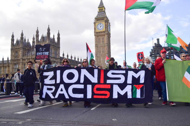 October 10, 2026, London, England, United Kingdom: Protesters holding a Zionism is Racism banner pass over Westminster Bridge past the Houses of Parliament as thousands of people march in support of Palestine. The protesters also called on the government to stop arming Israel and for sanctions on Israel. London United Kingdom - ZUMAv130 20261010_zip_v130_038 Copyright: xVukxValcicx