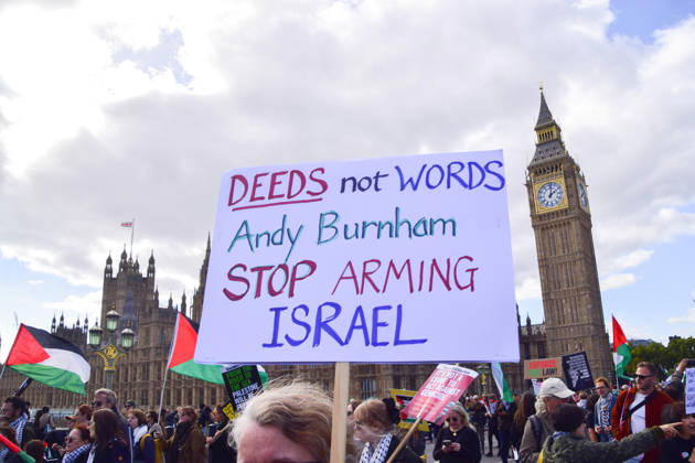 October 10, 2026, London, England, United Kingdom: A protester on Westminster Bridge holds a sign calling on Andy Burnham to stop arming Israel as thousands of people march in support of Palestine. The protesters also called on the government to stop arming Israel and for sanctions on Israel. London United Kingdom - ZUMAv130 20261010_zip_v130_041 Copyright: xVukxValcicx