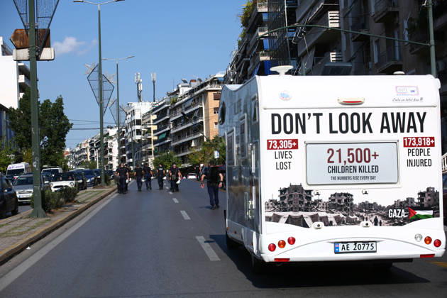 October 10, 2026, Athens, Attica, GREECE: A camper van displaying messages about casualties in Gaza travels along the route of a pro-Palestinian march as riot policemen walk ahead. Athens GREECE - ZUMAx103 20261010_zip_x103_016 Copyright: xHarrisxXanthopoulosx