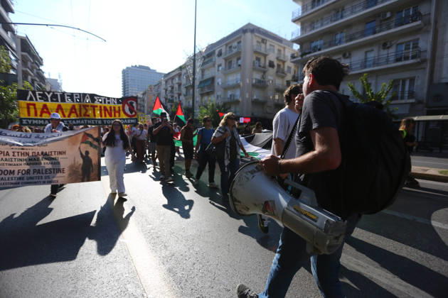 October 10, 2026, Athens, Attica, GREECE: A demonstrator speaks through a megaphone as protesters march behind him carrying Palestinian flags and banners. Athens GREECE - ZUMAx103 20261010_zip_x103_017 Copyright: xHarrisxXanthopoulosx