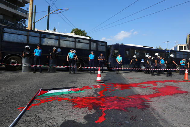 October 10, 2026, Athens, Attica, GREECE: Police officers stand behind a cordon near police buses, as red paint and a Palestinian flag lie on the road during a pro-Palestinian demonstration. Athens GREECE  - ZUMAx103 20261010_zip_x103_026 Copyright: xHarrisxXanthopoulosx
