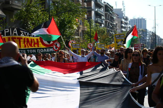October 10, 2026, Athens, Attica, GREECE: Demonstrators carry a large Palestinian flag during a pro-Palestinian march, with a protester raising both arms in the background. Athens GREECE - ZUMAx103 20261010_zip_x103_021 Copyright: xHarrisxXanthopoulosx
