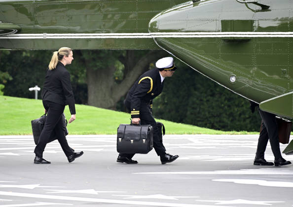 Aides carrying the briefcases referred to as the football board Marine One to accompany United States President Donald J Trump as he departs the South Lawn of the White House in Washington, DC, USA, en route Clarksville, Tennessee on Saturday, October 10, 2026. The President will participate in a campaign rally for Tennessee Republican candidates on the ballot in November. Copyright: xRonxSachsx xPoolxviaxCNPx MediaPunchx