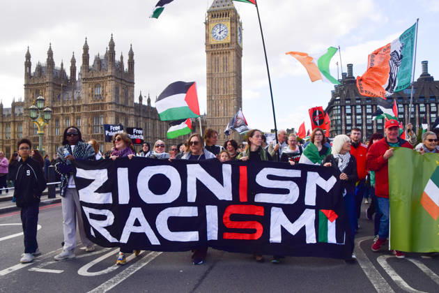October 10, 2026, London, England, United Kingdom: Protesters hold a Zionism is racism banner as they pass over Westminster Bridge past the Houses of Parliament during the National March for Palestine. Thousands of people marched in Central London marking three years of what the protest organisers call the genocide against the Palestinian people in Gaza London United Kingdom - ZUMAv130 20261010_zip_v130_074 Copyright: xVukxValcicx