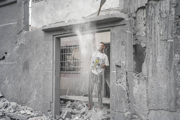 Israeli attack on Az-Zawayda area in Gaza DEIR AL-BALAH, GAZA, PALESTINE - OCTOBER 11: A man stands in the doorway of a damaged building as dust falls around him following an Israeli airstrike targeting a building belonging to the Buheysi family in the town of Az-Zawayda, near Deir al-Balah in the central Gaza Strip, on October 11, 2026. Israeli forces carried out the strike despite the ceasefire, destroying the targeted building and damaging surrounding structures. Adam Bilal Anadolu Deir Al-Balah Gaza. Editorial use only. Please get in touch for any other usage. Copyright: x2026xAnadoluxAdamxBilalx