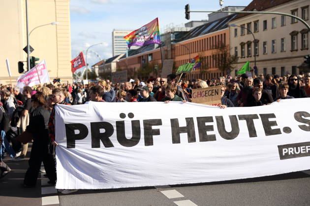 Protesters stand on Breite Straße holding a banner reading Review Today, Ban Tomorrow during a demonstration calling for the Federal Constitutional Court to review far-right parties, Potsdam, October 10, 2026. Review Demonstration in Potsdam