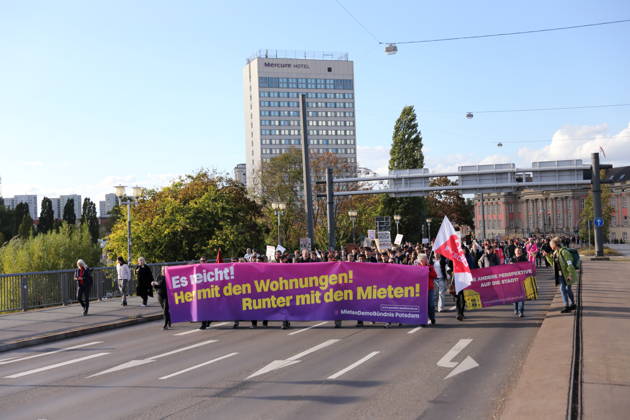 Protesters march across the Lange Bridge carrying a banner reading Enough Is Enough—Give Us Housing, Lower the Rents during a demonstration against the housing crisis and rising rents, Potsdam, October 10, 2026. Rent Protest in Potsdam