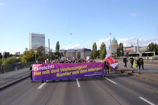 Protesters march across the Lange Bridge carrying a banner reading Enough Is Enough—Give Us Housing, Lower the Rents during a demonstration against the housing crisis and rising rents, Potsdam, October 10, 2026. Rent Protest in Potsdam